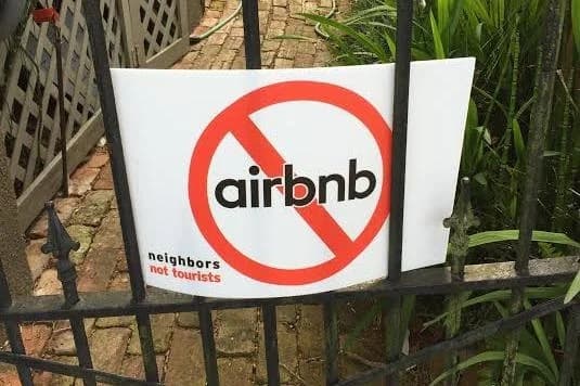 A sign on a gate reads "No Airbnb - neighbors not tourists."