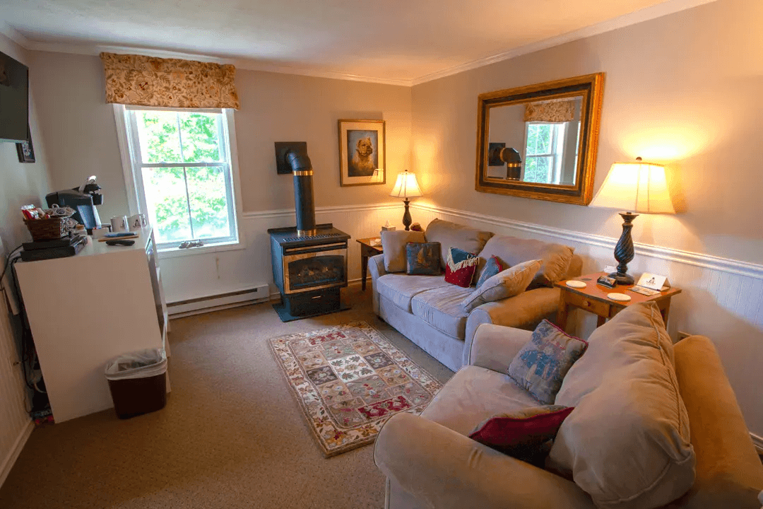 Cozy living room featuring two sofas, a fireplace, and warm lighting.
